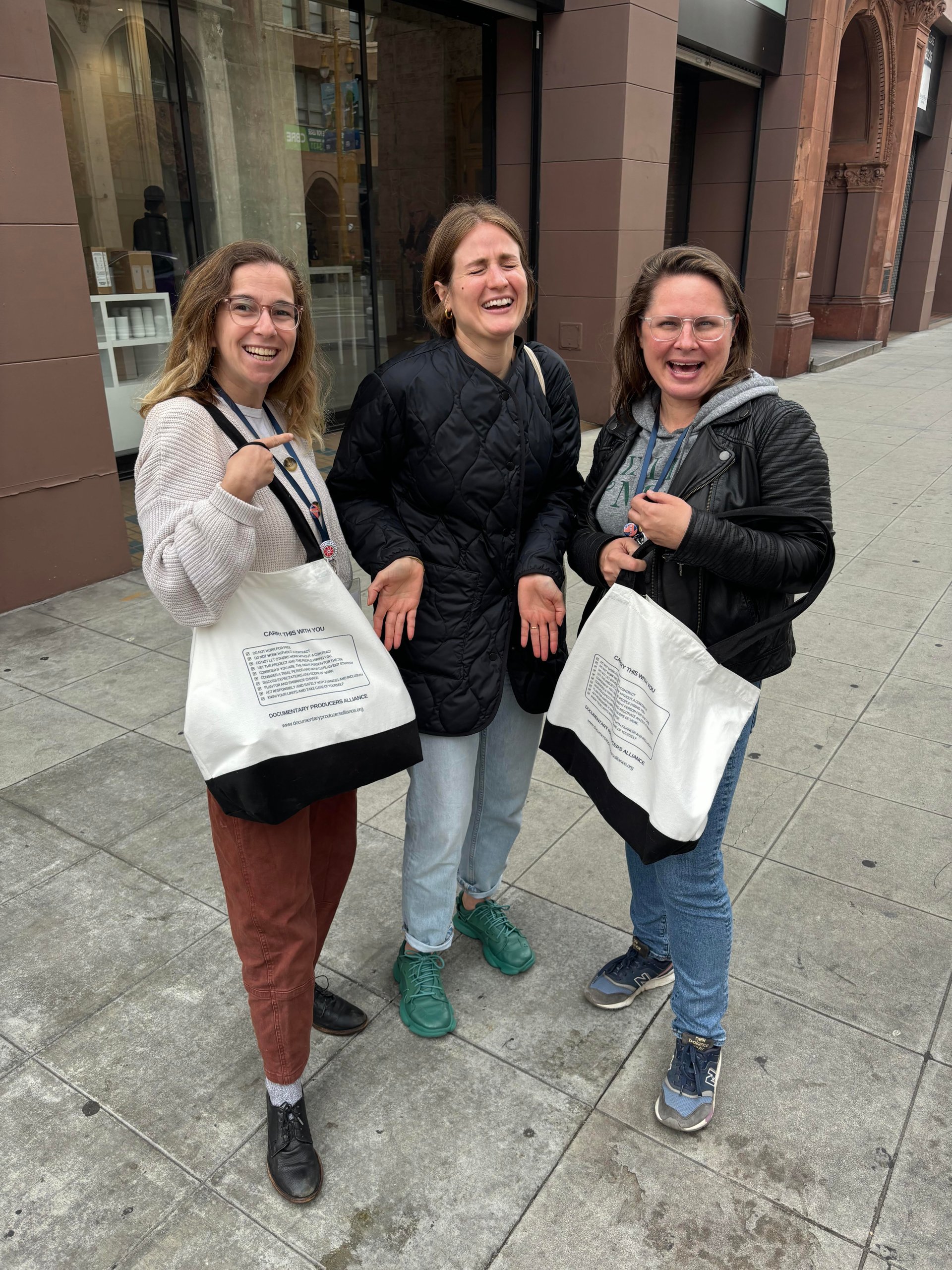 3 people holding their DPA tote rules for producers bag